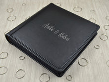 Carica l&#39;immagine nel visualizzatore di Gallery, example of matte silver vinyl personalization on a black leather cover of a photo album by Giovelli Design
