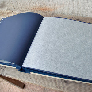 opened album with blue pages and protective tissue by Giovelli Design