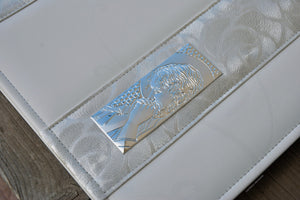 particular of a holy bilaminated silver plaque on a white first communion photo album by Giovelli Design